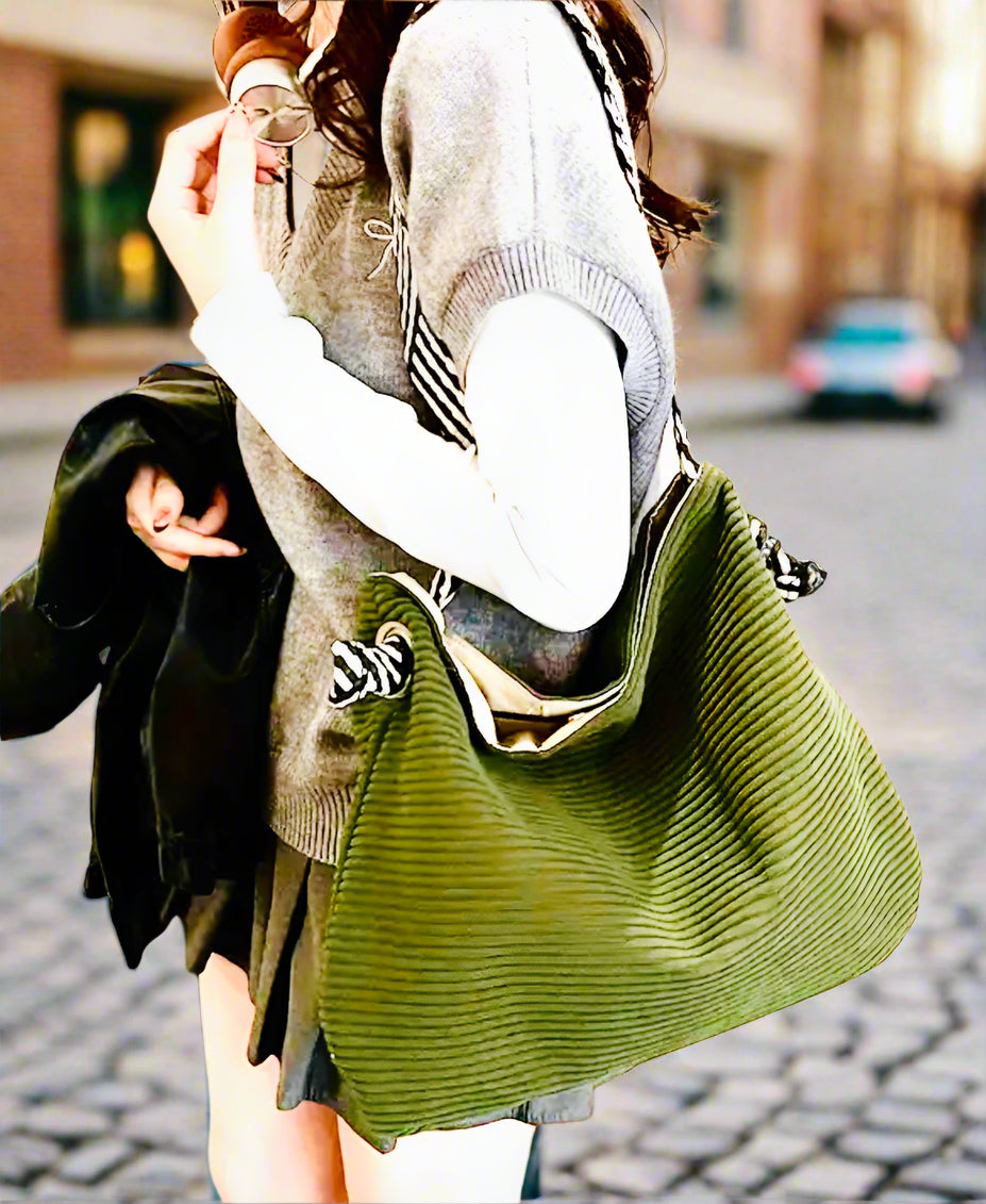 Woman holding a green handbag indoors